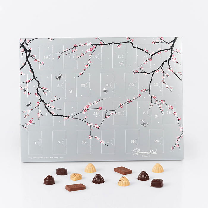 Summerbird julekalender i sølv design med 24 låger fyldt med økologisk luksuschokolade i 12 varianter, inkl. marcipan, ganache og små barer.