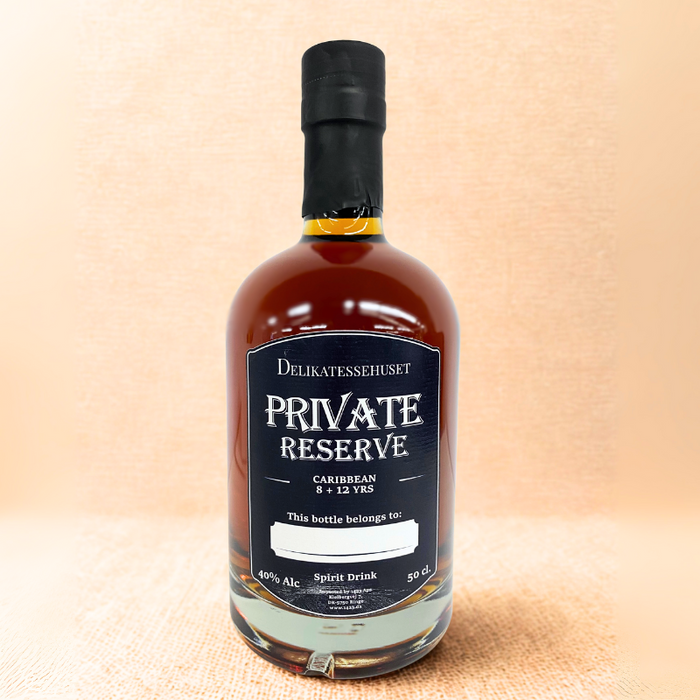 Flaske med Caribbean-rom, blend af 8 og 12 års lagring, med gylden væske og personlig etiket med mulighed for eget navn, omgivet af varm og indbydende stemning.