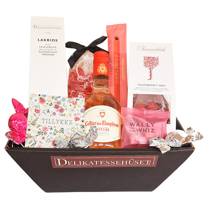 Sød feminin gavekurv med lille flaske fransk rosévin, chokolade, lakrids, mandler vingummi m.m.