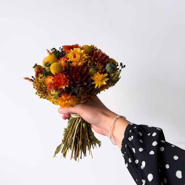 Dekorativ lille evighedsbuket med tætpakkede orange blomster, ideel som gave eller til hyggelig indretning.