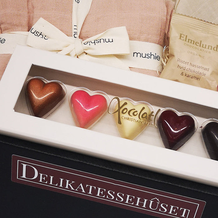 Barselsgave til den nyfødte pige med stofbleer, nusseklud og chokolade til mor og far