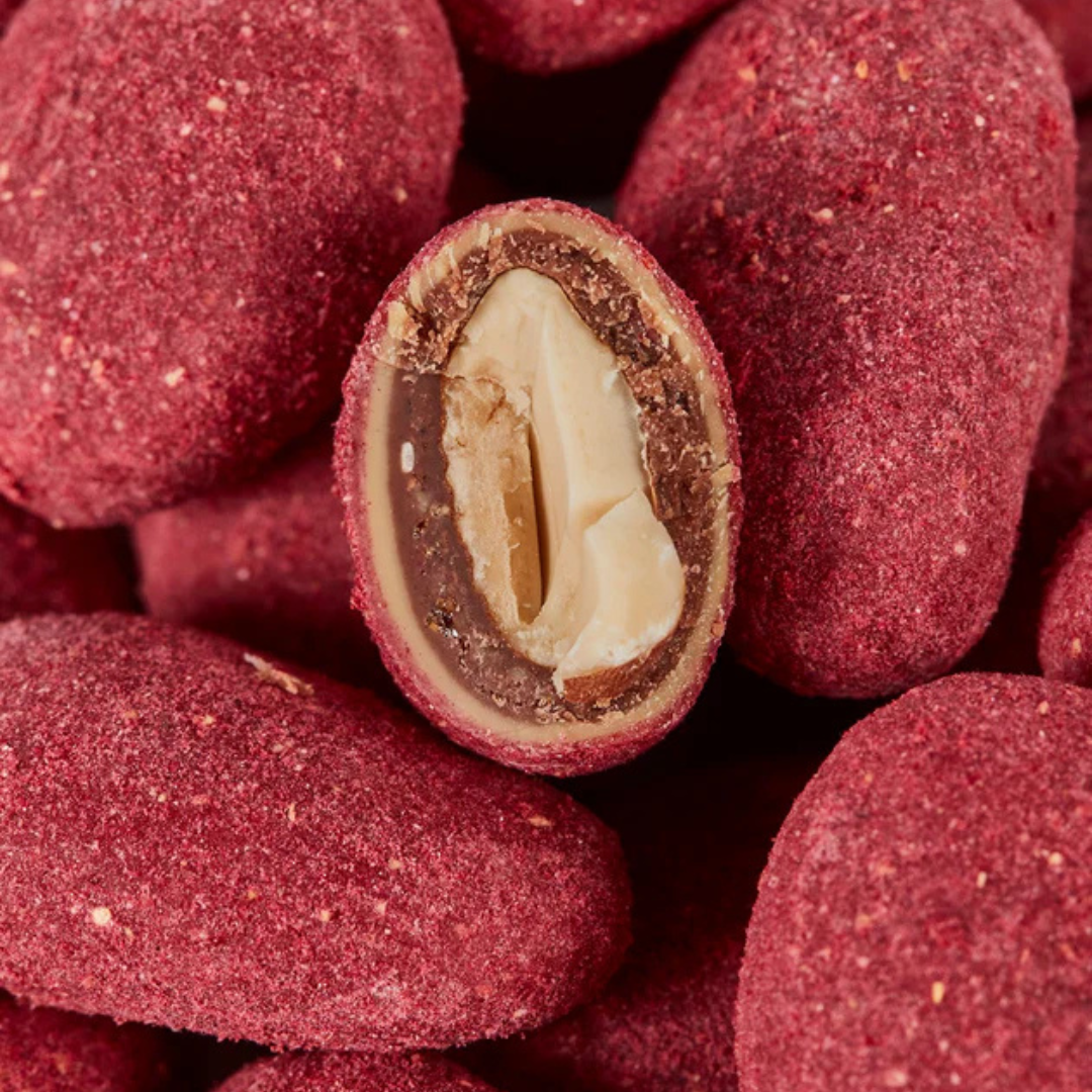 Nærbillede af Summerbird Raspberry Red dragerede mandler med hvid chokolade og hindbærstøv.