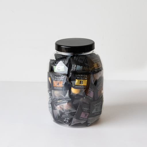 Bøtte med 50 stk. chokoladedrageret lakrids fra Lakrids by Bülow, et miks af seks varianter i flowpacks – ideel som dele-gave til virksomheder eller som luksus snack.