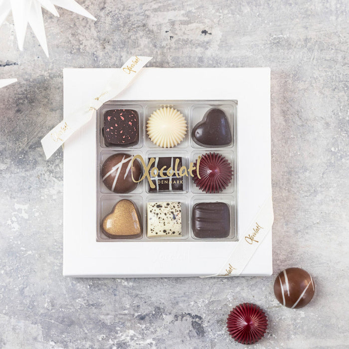Eksklusiv gaveæske “Christiansfelder Star 9” fra Xocolatl med 9 håndlavede fyldte luksuschokolader i smukke julefarver – marcipan, hasselnød, citron, lakrids, romkaramel, appelsin, kirsebærmarcipan, kahlua og saltkaramel.