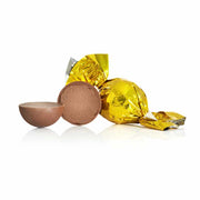 Guldindpakket chokoladetrøffel fra Cocoture ved siden af en overskåret trøffelkugle med cremet fyld.