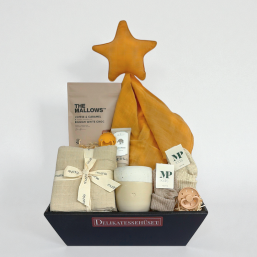 Smuk barselsgave med babyprodukter og forkælelse, inklusiv nusseklud, sutter, babystrømper, stofbleer, håndlavet krus, babycreme og skumfiduser – perfekt til babyshower eller fødselsgave.