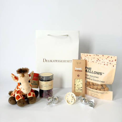 Gavepose til nybagte forældre med blød girafbamse, sut og søde delikatesser som chokolade, vingummi og karamelsnacks
