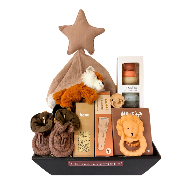 Perfekt gavekurv til babyshower eller barsel fyldt med legetøj, sut, krammebamse og chokolade