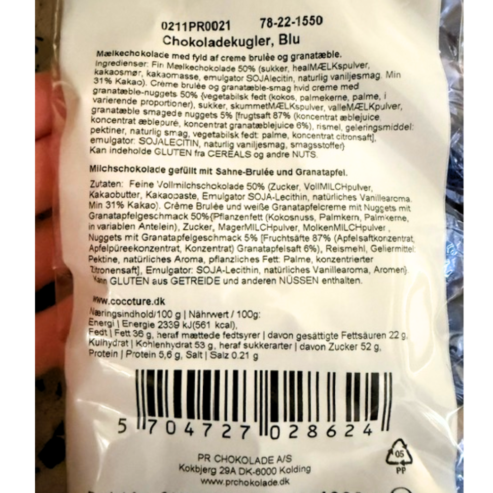 Bagside af Cocoture chokoladekugler med ingrediensliste og smag af creme brulee og granatæble.