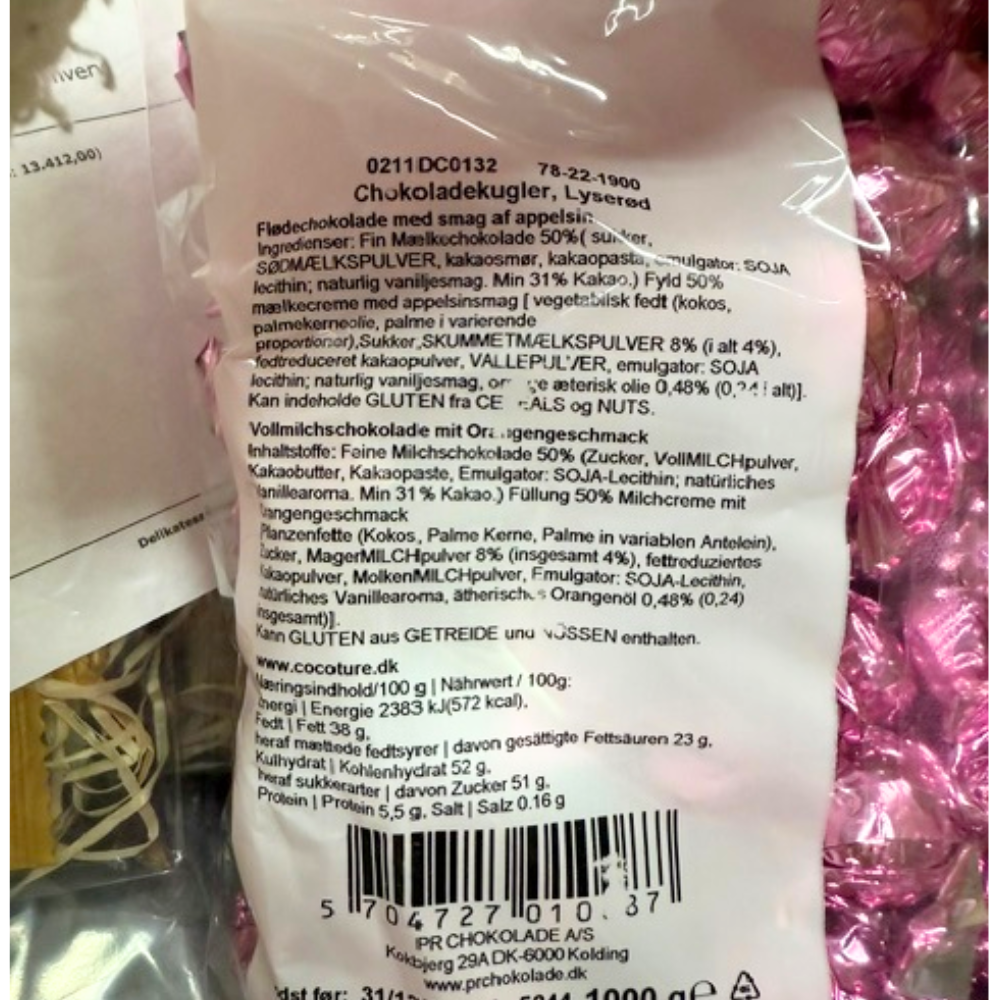 Lyserøde chokoladekugler med appelsinsmag fra Cocoture, vist med ingrediensliste og næringsindhold på posen.