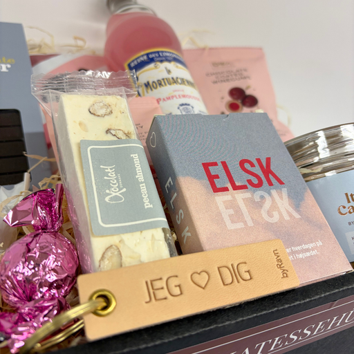 Lyserød gavekurv med forskellige lækkerier