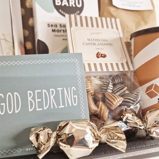 Send en gavekurv med ønsket om en god bedring. Gave med chokolade, varm kakao, boller og skønne bolsjer