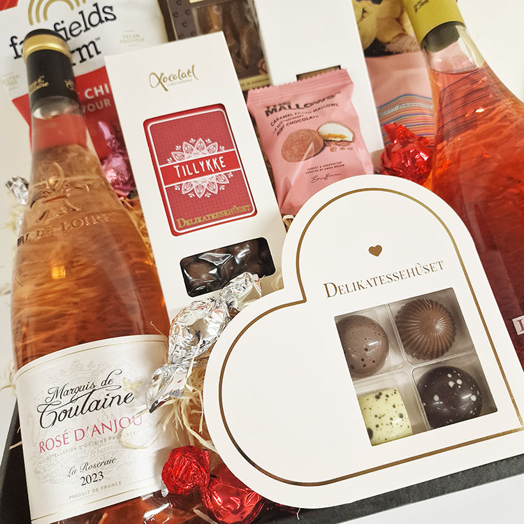 Gavekurv med rosevin, chokolade og delikatesser til at sige hjerteligt tillykke.