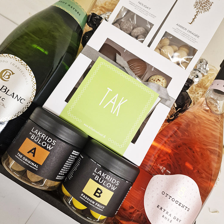 Gavekurv med Cava, rosé bobler, Summerbird chokolade, Lakrids by Bülow og et grønt Tak kort.