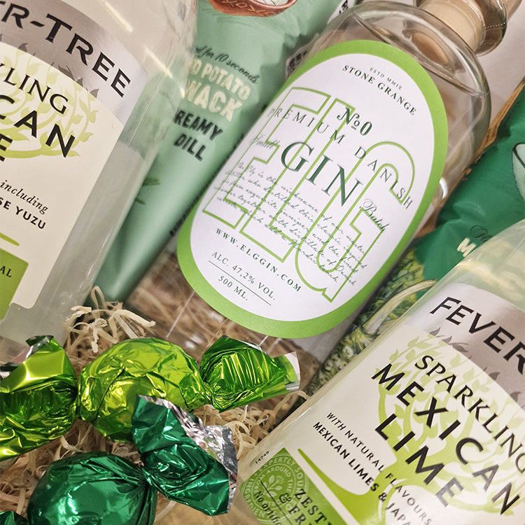 Nærbillede af en gin gavekurv med Elg Gin, Fever-Tree tonic, chips og grønne chokoladekugler.