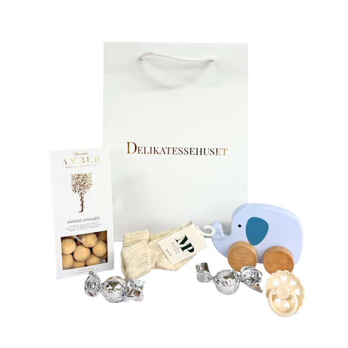 Barselsgave med chokolade, babystrømper, sut og træelefant på hjul