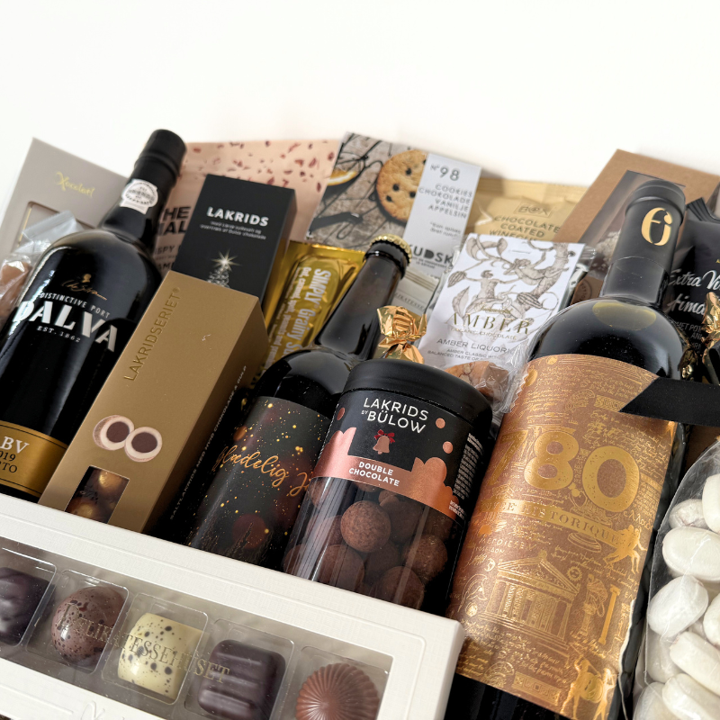 Kæmpe luksus gavekurv med vin, lakrids, chokolade og delikatesser, smukt anrettet i en fletkurv med cellofan og gavebånd
