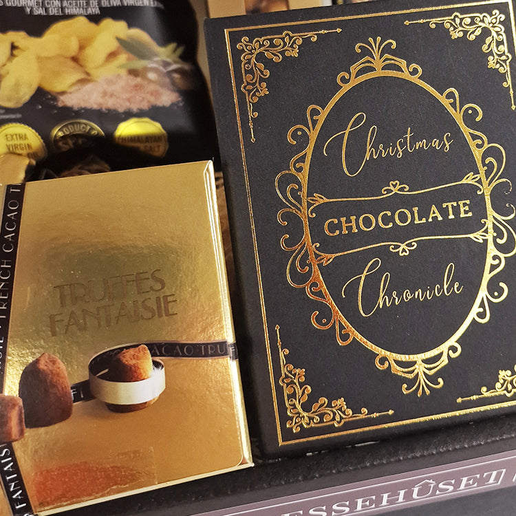 Lækker julekurv uden alkohol med chokolade trøfler og Christmas Chocolate Chronicle gaveæske i guld og sort.