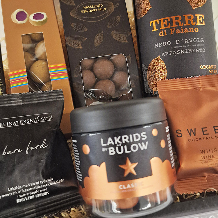 Lille julekurv med sort og kobber tema indeholdende Lakrids by Bülow, vin og specialiteter.