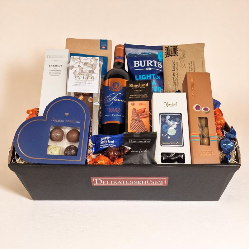 Luksuriøs gavekurv fra Delikatessehuset med rødvin, chokolade, lakrids og diverse delikatesser.