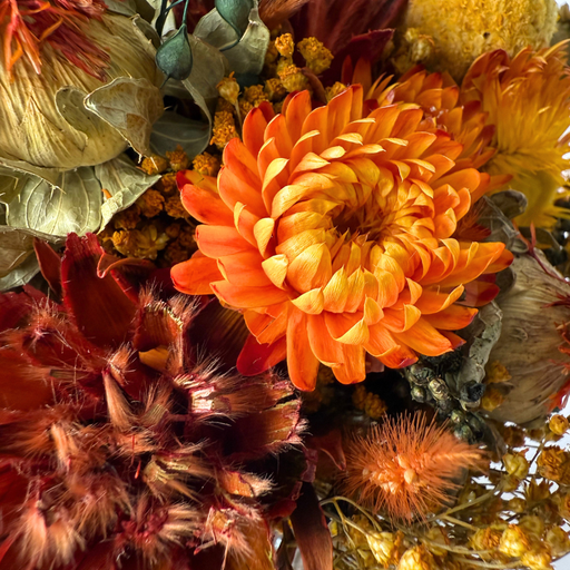 Smuk mini-buket af evighedsblomster i levende orange toner, håndbundet til langvarig glæde.