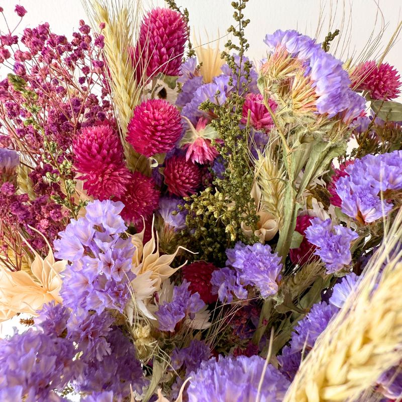 Frodig evighedsbuket med tørrede blomster i harmoniske nuancer af lyserød, lilla, hvid og grøn, der bevarer sin skønhed år efter år.