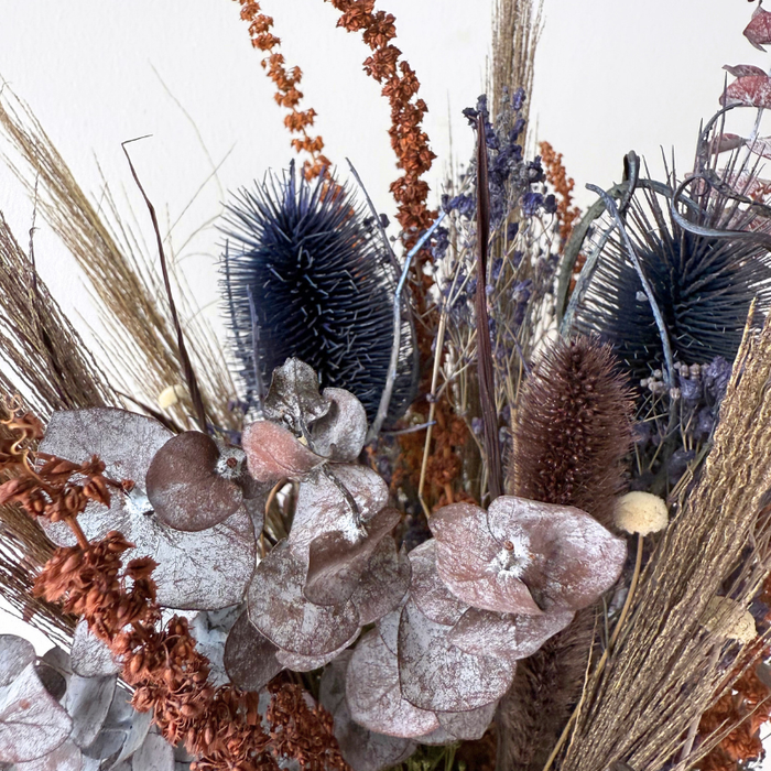 Elegant buket med tørrede blomster i neutrale og dæmpede toner, inspireret af vinterens rolige farver.