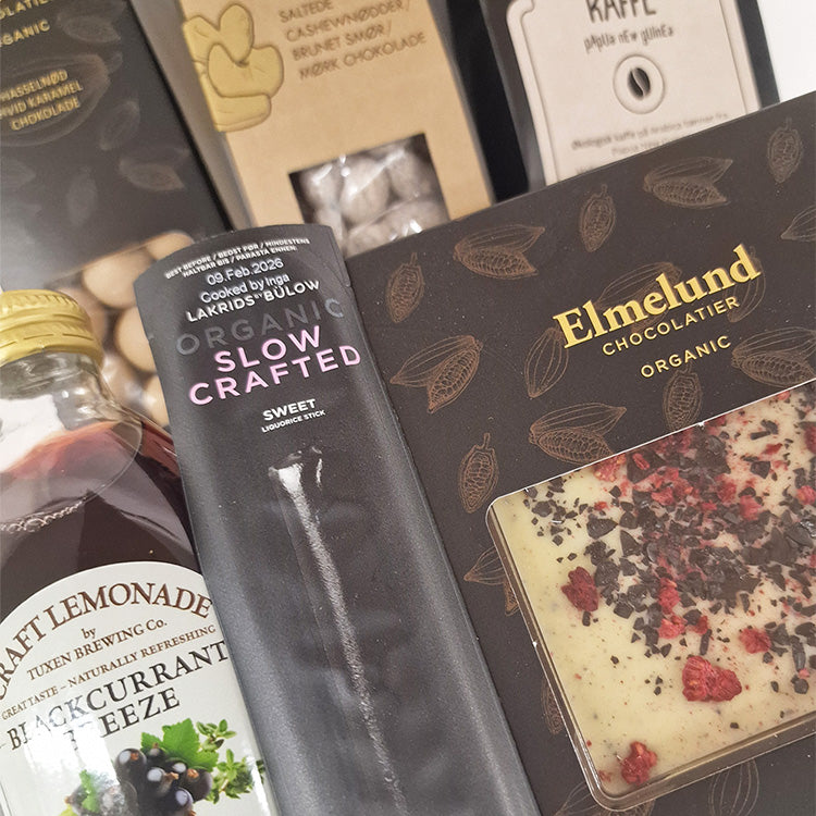 Tætbillede af økologisk gavekurv med chokolade fra Elmelund, lakrids fra Bülow, kaffe og lemonade.