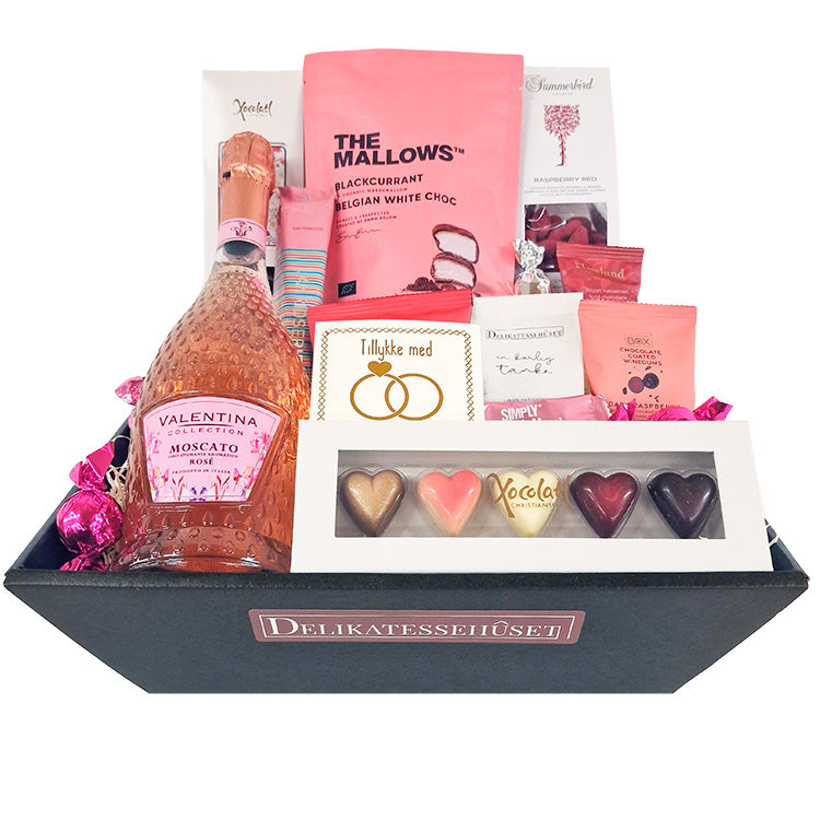 Lyserød gavekurv fyldt med Moscato Rosé, chokoladehjerter og søde lækkerier til en du elsker.
