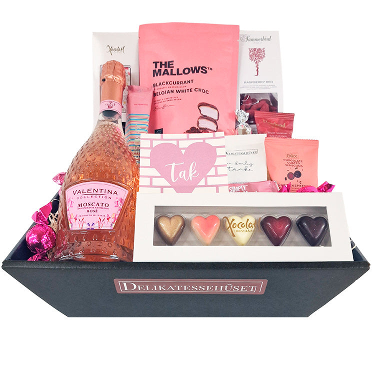 Lyserød gavekurv med Moscato Rosé, chokoladehjerter og The Mallows slik som en takkegave.