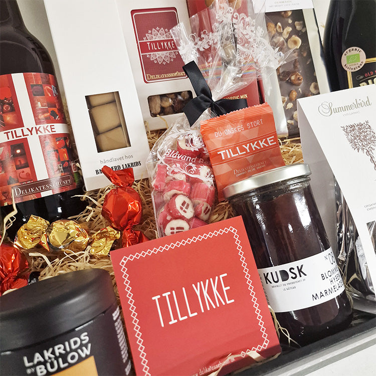 Gavekurv med rødvin, chokolade, lakrids og marmelade med tillykke hilsen til fejring.