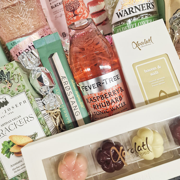 Stor flot gavekurv fyldt med gin og tonic og søde snacks