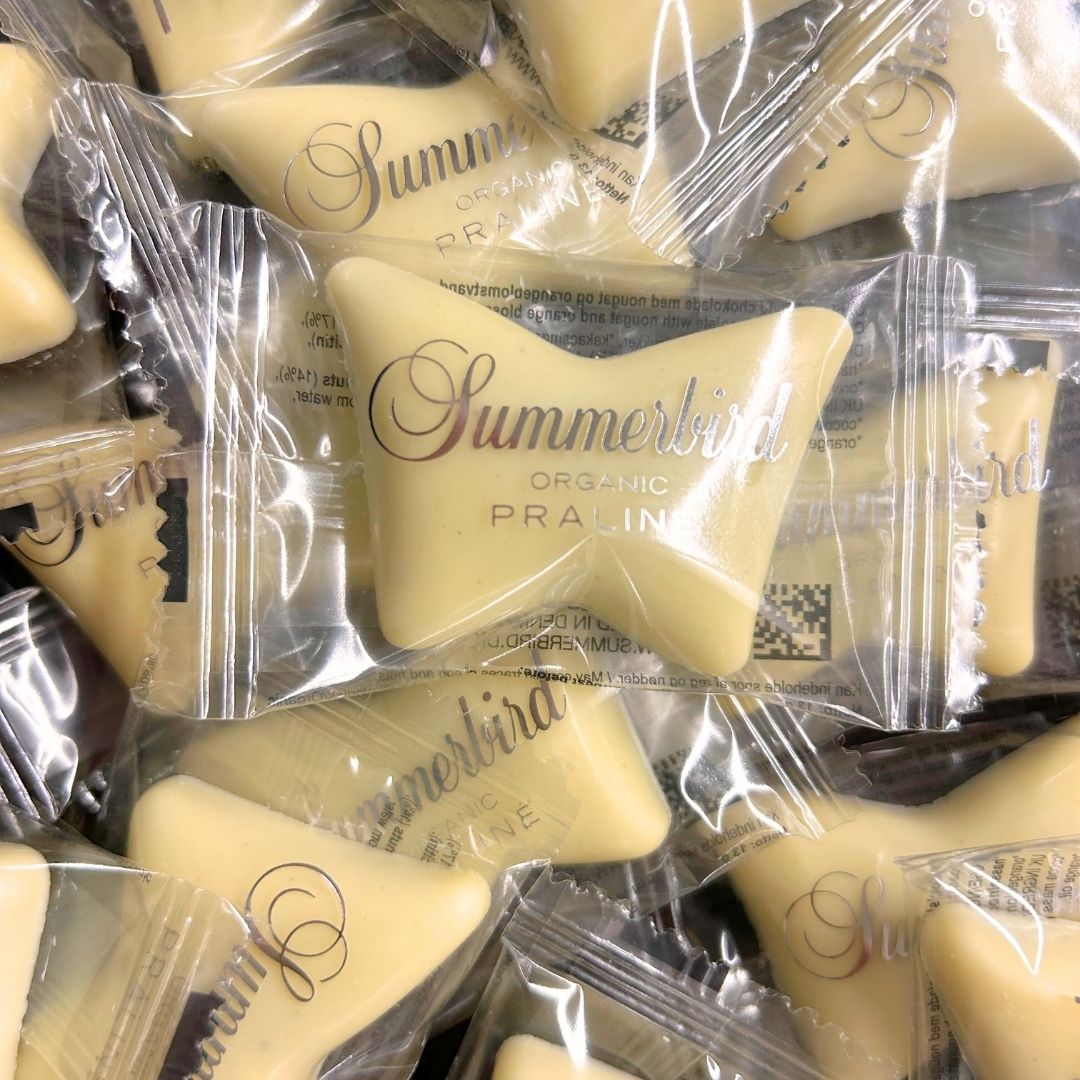 Nærbillede af Summerbird Organic Praliné sommerfugle chokolader pakket ind i gennemsigtig plastfolie.