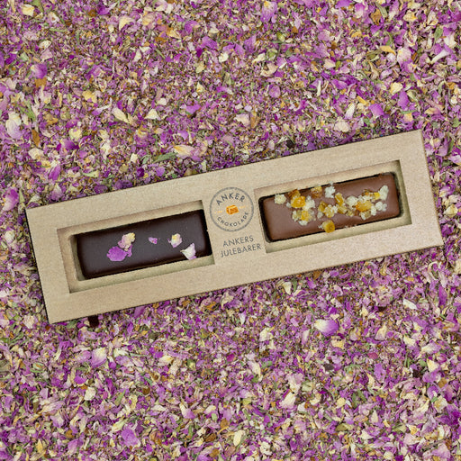 Sæt med to fyldte chokoladebarer: Blommer i portvin med 70% mørk chokolade og rosenblade samt “Honningkage” med nougat, krydderier, ingefær og appelsin.