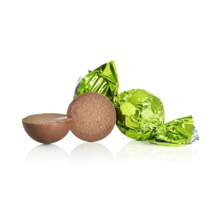 Chokoladekugler af mælkechokolade med chokolade og lakridsfyld, indpakket i grønt folie.