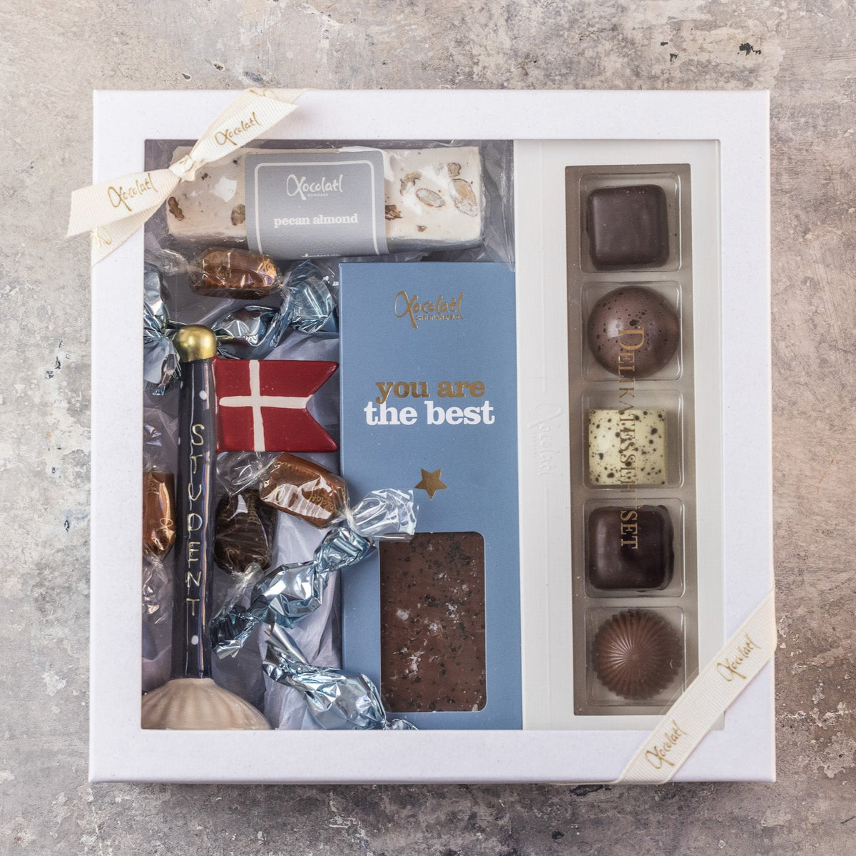 Gaveæske til den nye student med chokolade og et keramikflag med teksten "student"