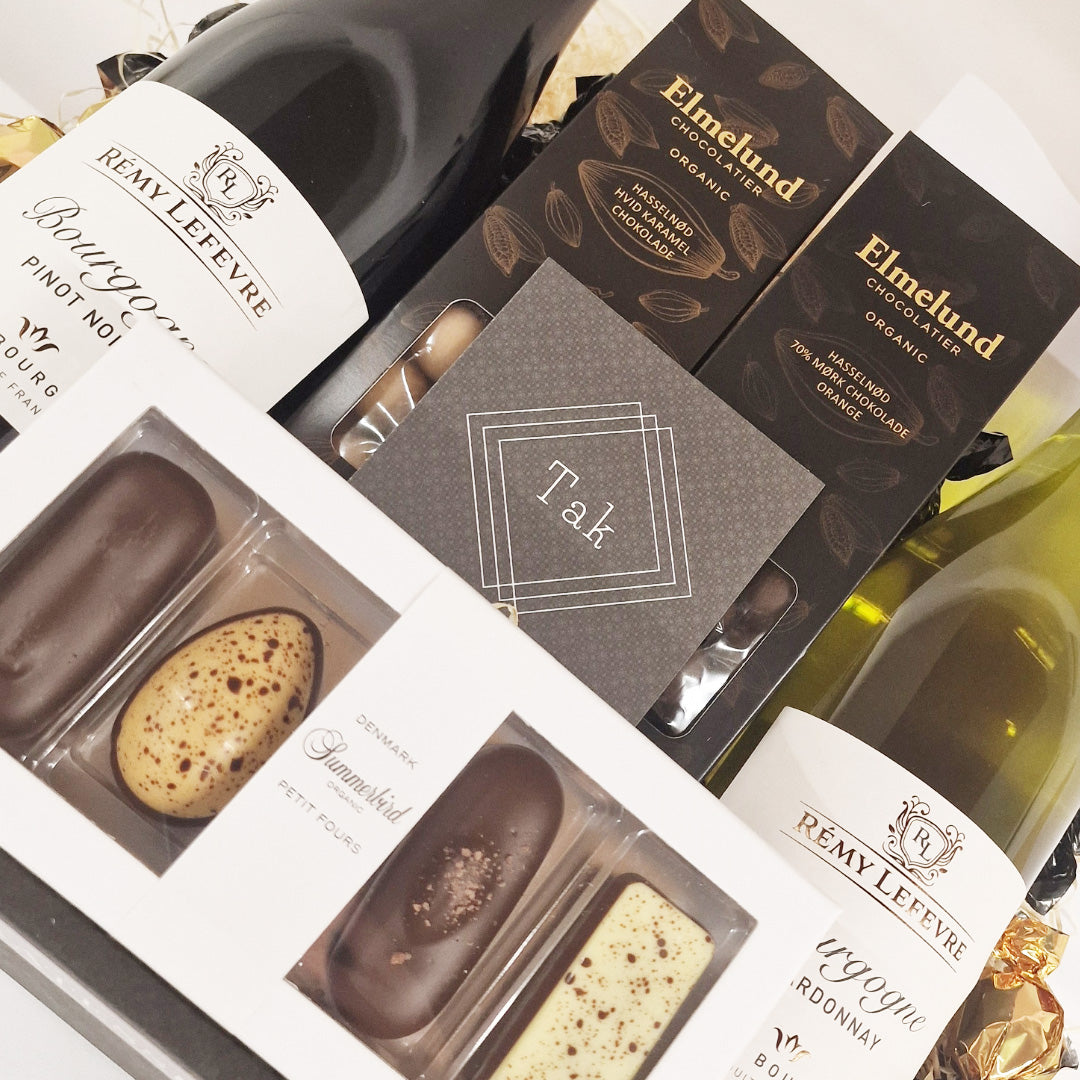 Eksklusiv tak gavekurv med rødvin, hvidvin, Summerbird chokolade, Elmelund chokolade og et personligt takkekort.