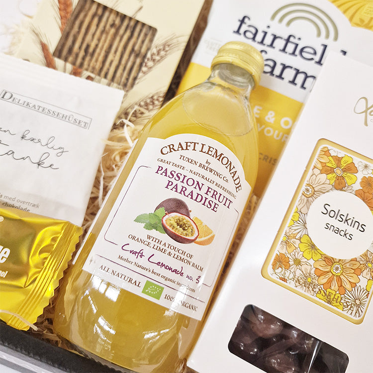 Gavekurv med gul passionfrugt lemonade og lækre solskins snacks til medarbejdere og kunder.