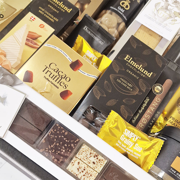 Nærbillede af luksuriøs gavekurv med gourmet chokolade, kakaotrøfler og lakrids fra Delikatessehuset.
